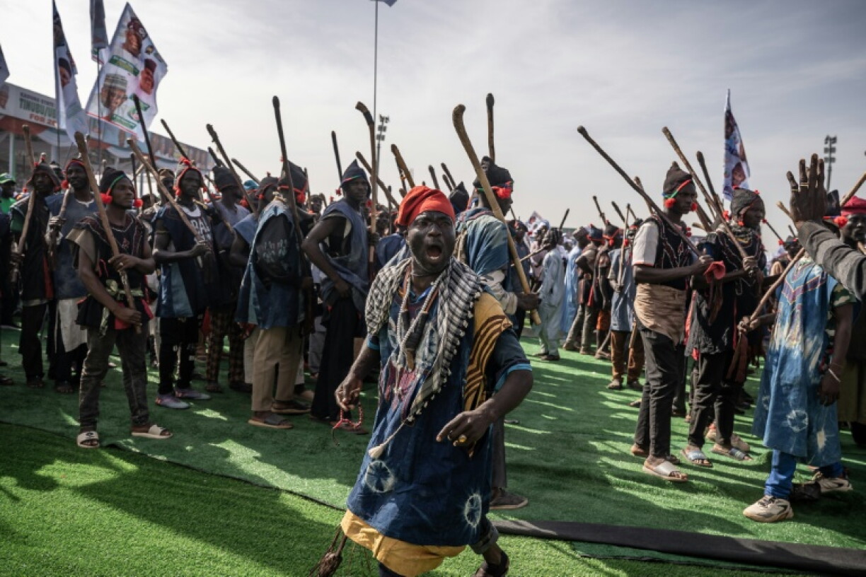 Supporters of Bola Tinubu's All Progressives Congress (APC) party march and dance during ahead of the president's campaign speech in Kaduna