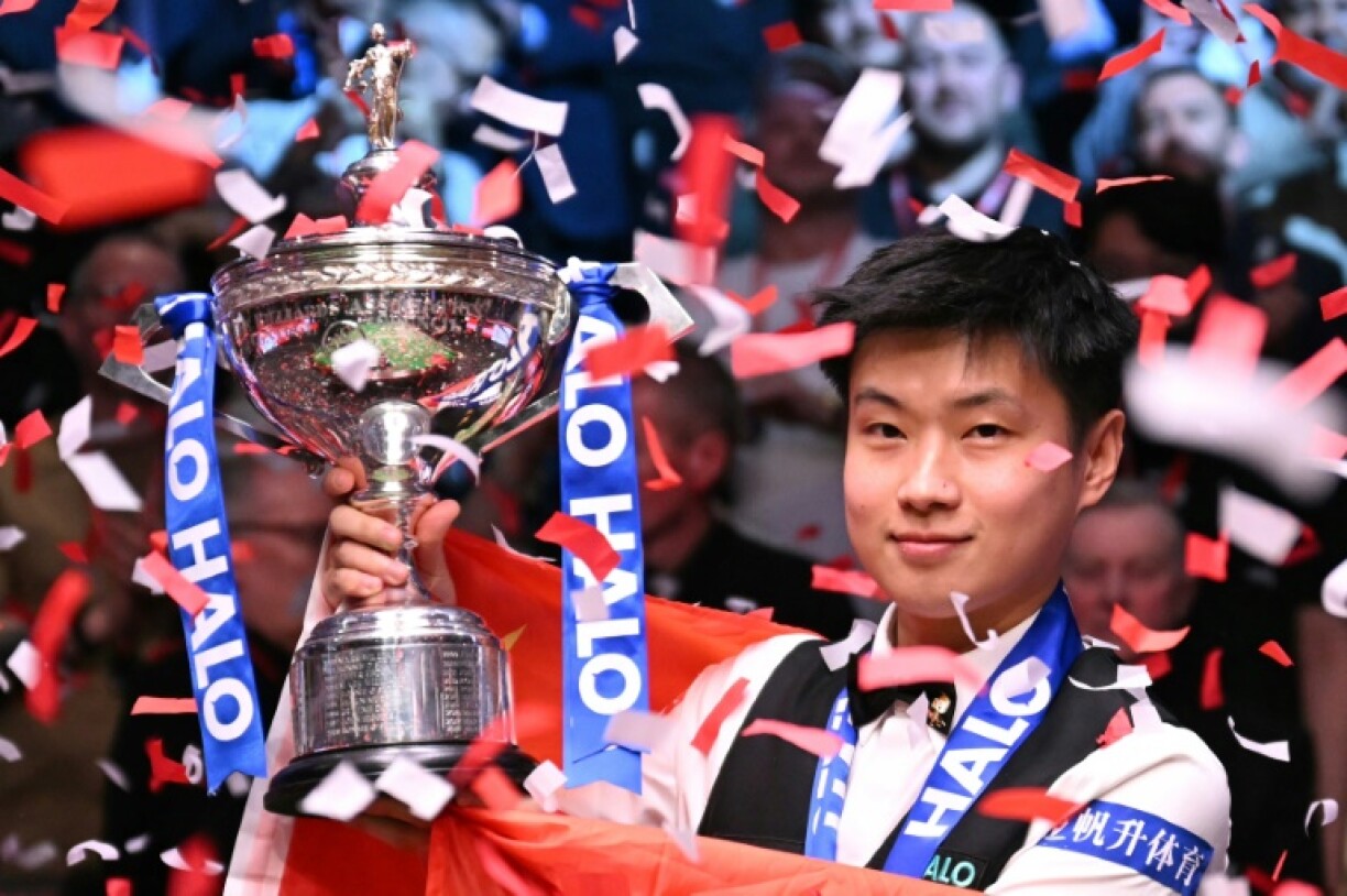 China's Zhao Xintong poses with the World Snooker Championship trophy