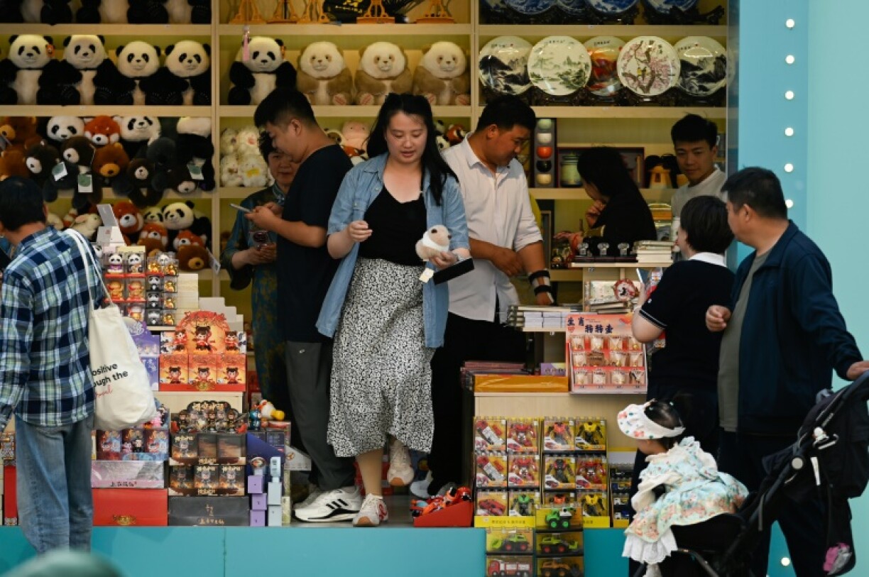 People visit a shop along a busy street in Beijing