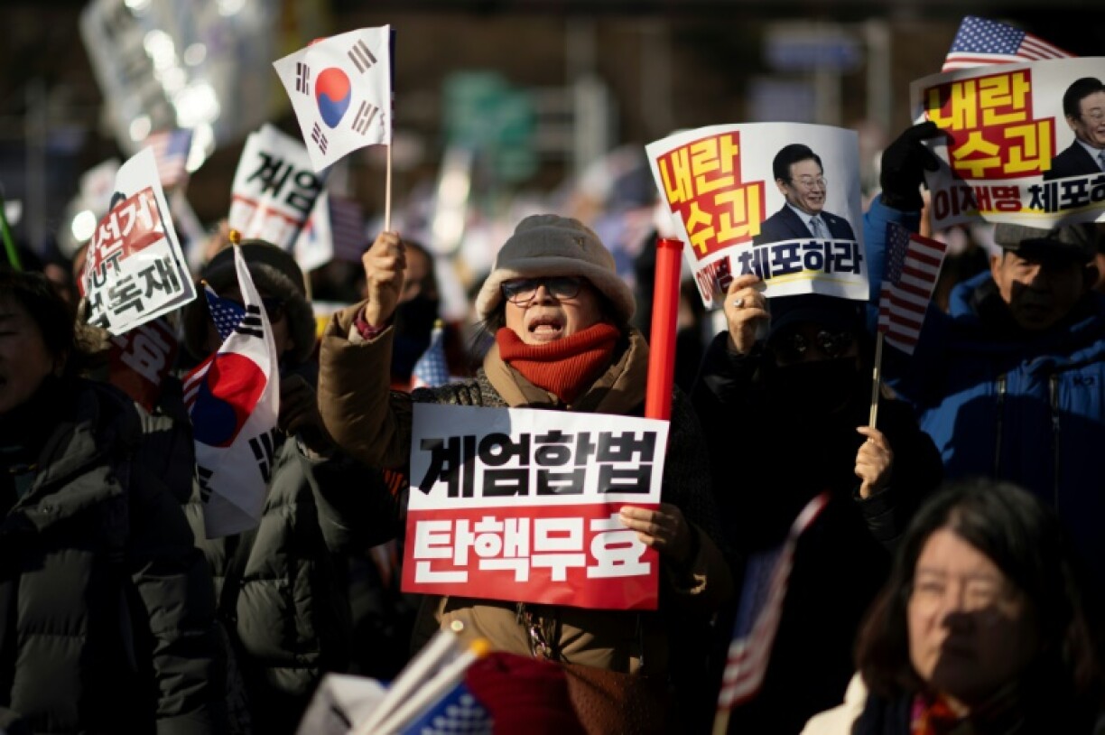 A woman holds a placard reading