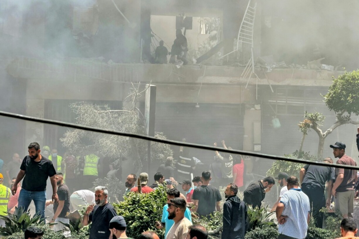 Des habitants recherchent des survivants sur le site d'une frappe aérienne israélienne qui a ciblé un bâtiment dans la banlieue sud de Beyrouth, le 14 juin 2026 au Liban