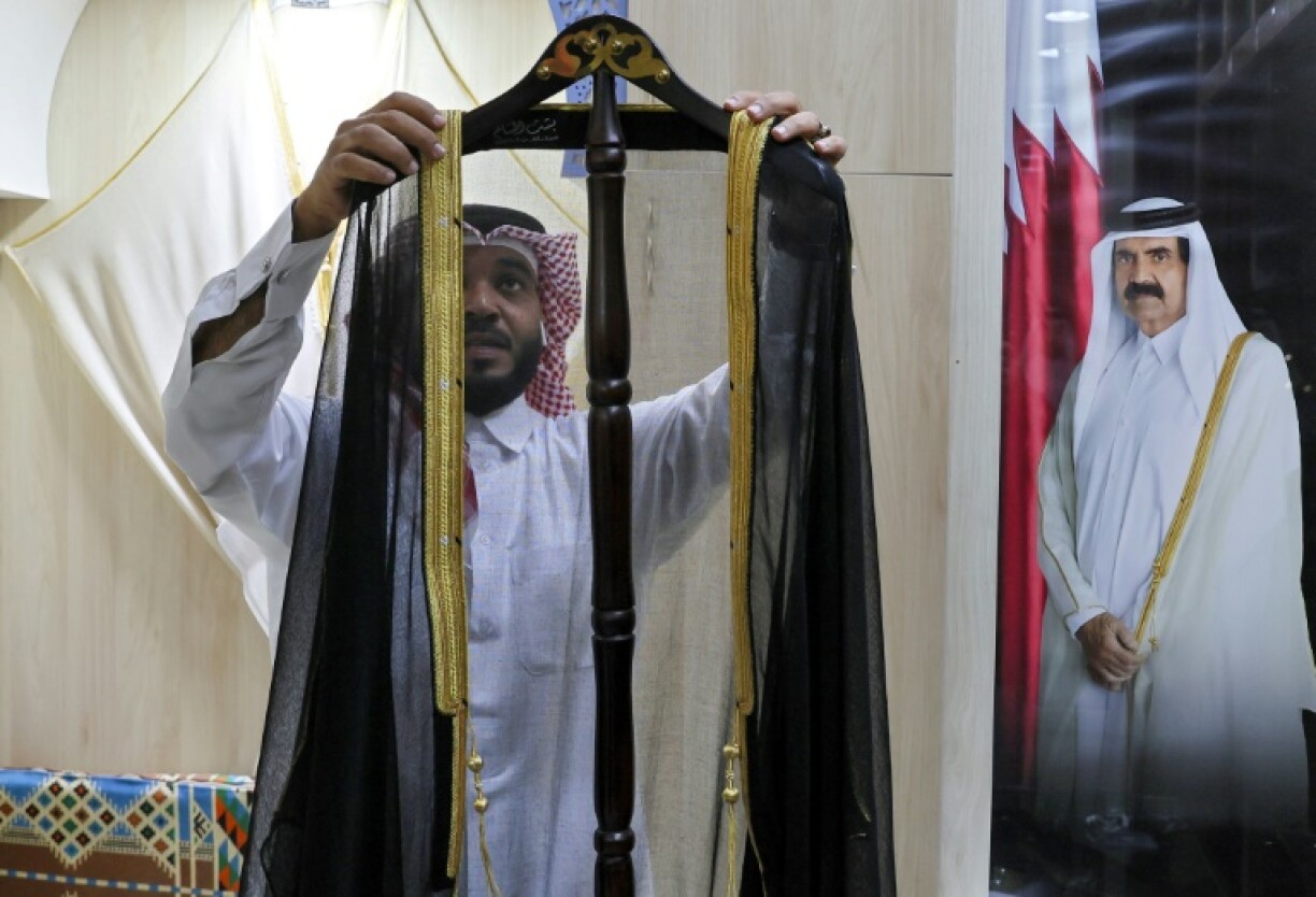 Un employé expose un manteau traditionnel qatari (