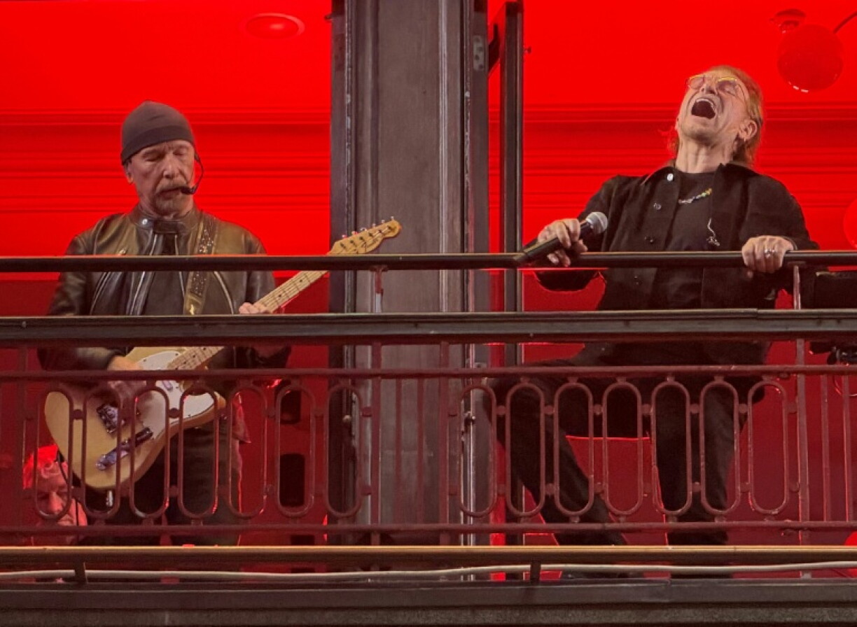 The Edge (L) and Bono (R) of Irish rock bank U2 perform on the balcony of Bewley's Oriental Cafe in central Dublin