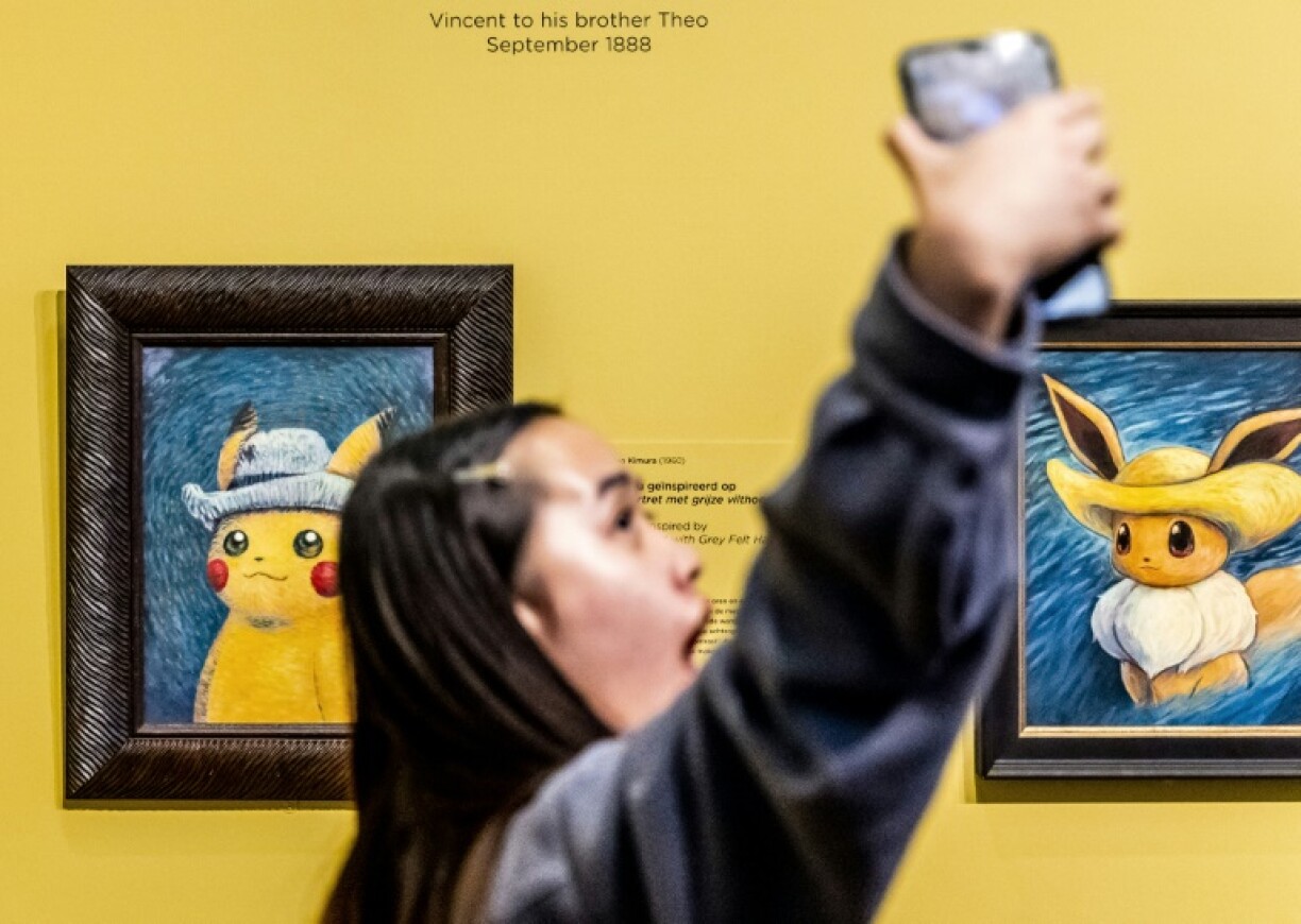 Une visiteuse photographie des peintures d'artistes inspirés par Pokémon au musée Van Gogh à Amsterdam
