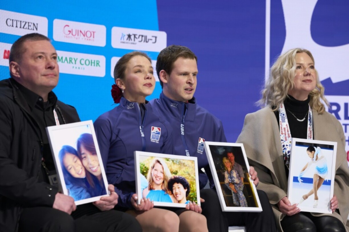 USA's Alisa Efimova and Misha Mitrofanov hold photos victims of the American Airlines flight 5342 disaster as they wai for their scores at the World Championships in Boston