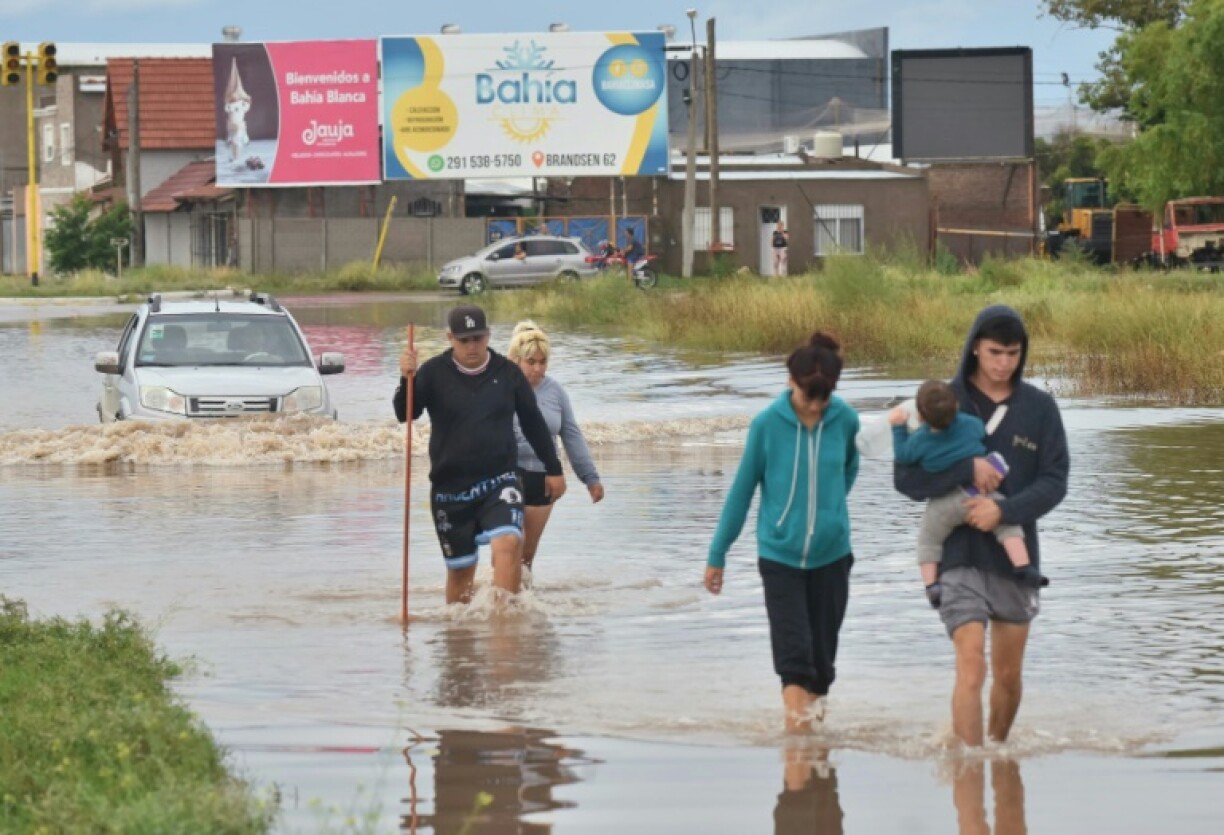 People wade through floodwater in Bahia Blanca, Argentina, on March 7, 2025