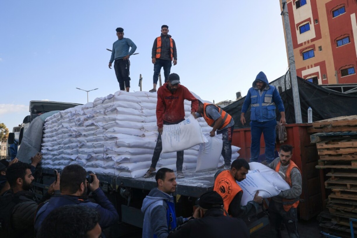 Des Palestiniens reçoivent des sacs de farine au centre de distribution de l'Unrwa du camp de réfugiés de Rafah, dans le sud de la bande de Gaza, le 21 novembre 2023