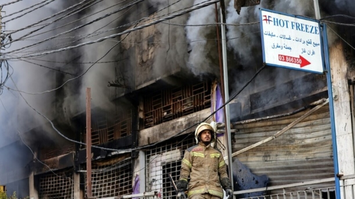 Un secouriste se tient devant un bâtiment incendié par une frappe israélienne qui a visé la banlieue sud de Beyrouth, le 6 octobre 2024