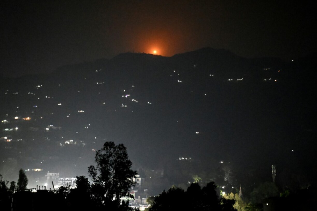 A flare goes up in air over the hill near the main town of Poonch district