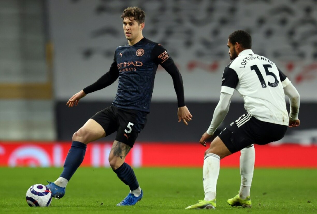 Le défenseur de Manchester City John Stones (g) face au milieu de Fulham Ruben Loftus-Cheek, le 13 mars 2021 à Londres