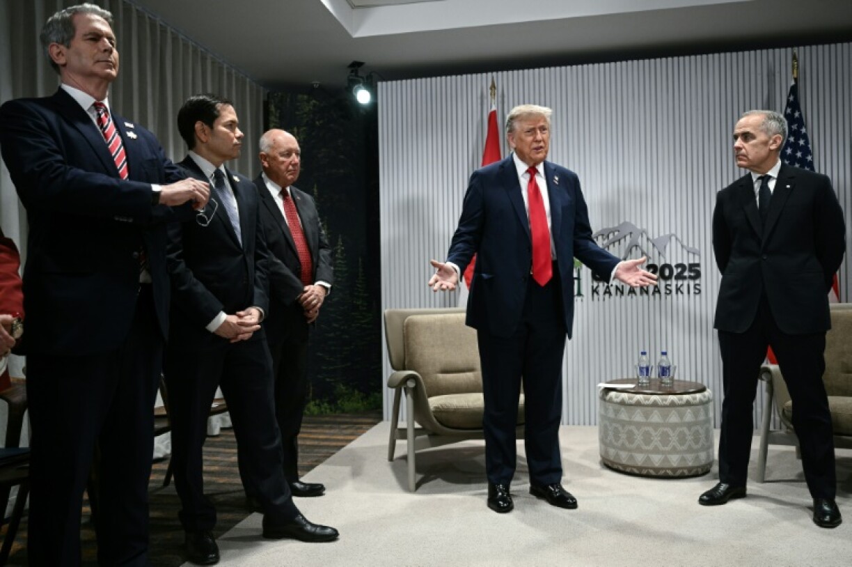 US President Donald Trump speaks as Canadian Prime Minister Mark Carney looks on as they meet during the Group of Seven summit in Kananaskis, Alberta, Canada
