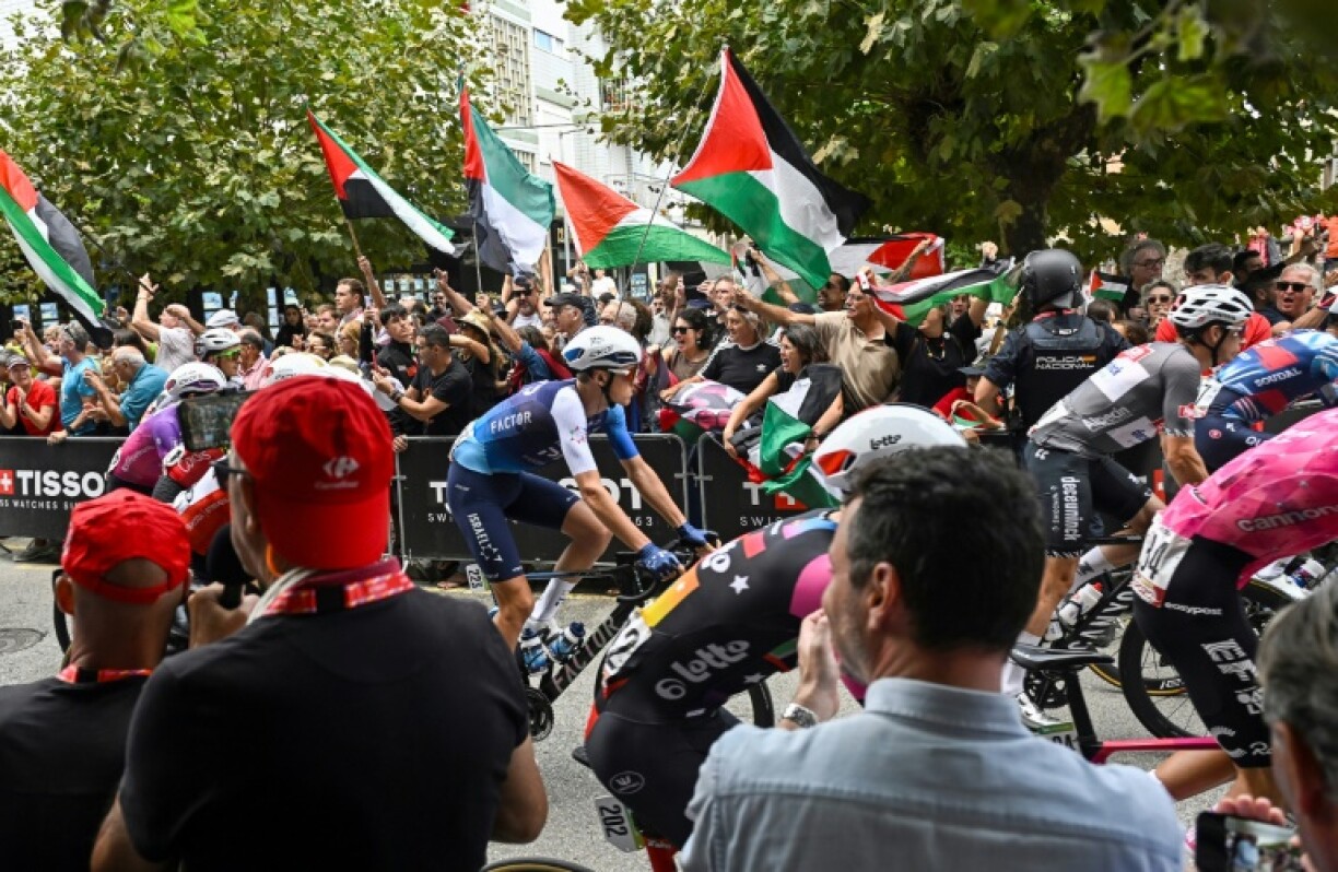 Israel Premier-Tech's Italian rider Marco Frigo passes pro-Palestinian demonstrators at the start of the 12th stage of the Vuelta a Espana, in Laredo