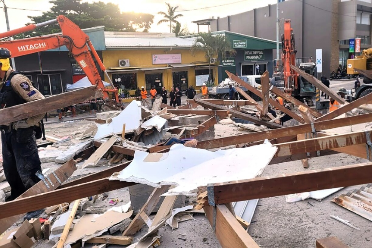 Australian rescue workers comb through the site of a collapsed building in Port Vila, the capital city of Vanuatu
