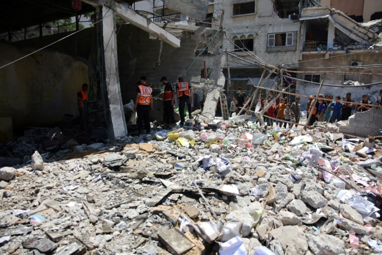 Des employés de la municipalité de Gaza et la Défense civile inspectent un bâtiment de la municipalité détruit par un bombardement israélien dans la ville de Gaza, le 21 juin 2024