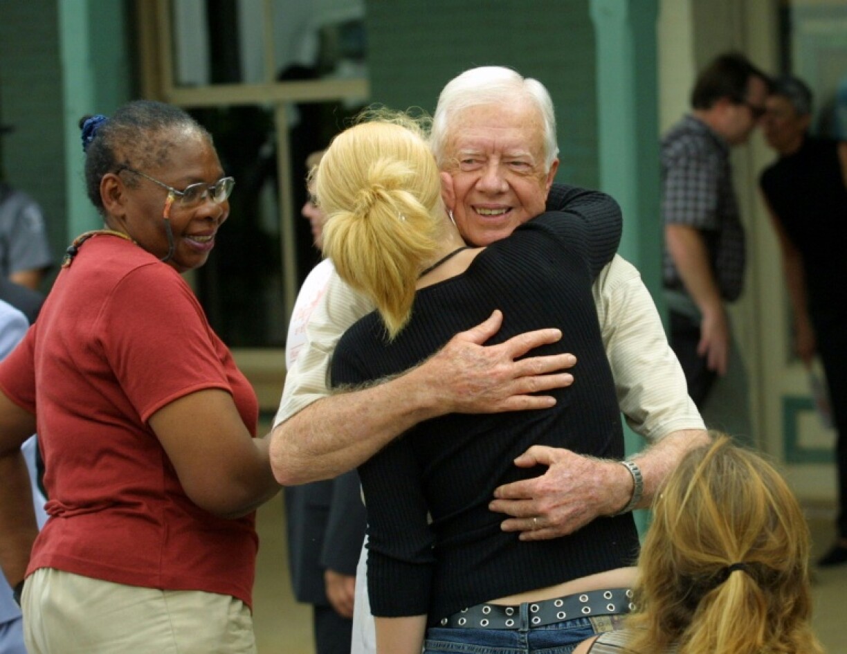 Former US president Jimmy Carter receives hugs from the crowd after a press conference in Plains, GA
