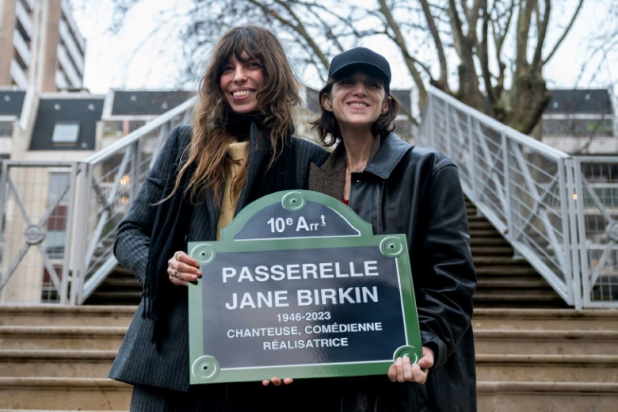 L'actrice et chanteuse française Charlotte Gainsbourg (à droite) et la chanteuse Lou Doillon présentent un panneau "Passerelle Jane Birkin" lors d'une cérémonie d'hommage à l'actrice et chanteuse franco-britannique Jane Birkin, Quai de Valmy à Paris le 13 décembre 2025