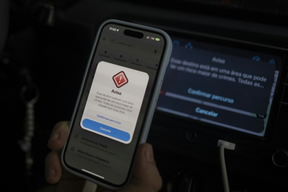 An Uber driver show his cellphone with a warning from the Waze app that says: This destination is in an area that may have a higher risk of crime