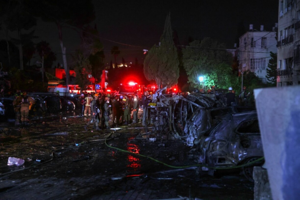 Israeli emergency and security service members deploy at a site hit by an Iranian rocket in the city of Haifa