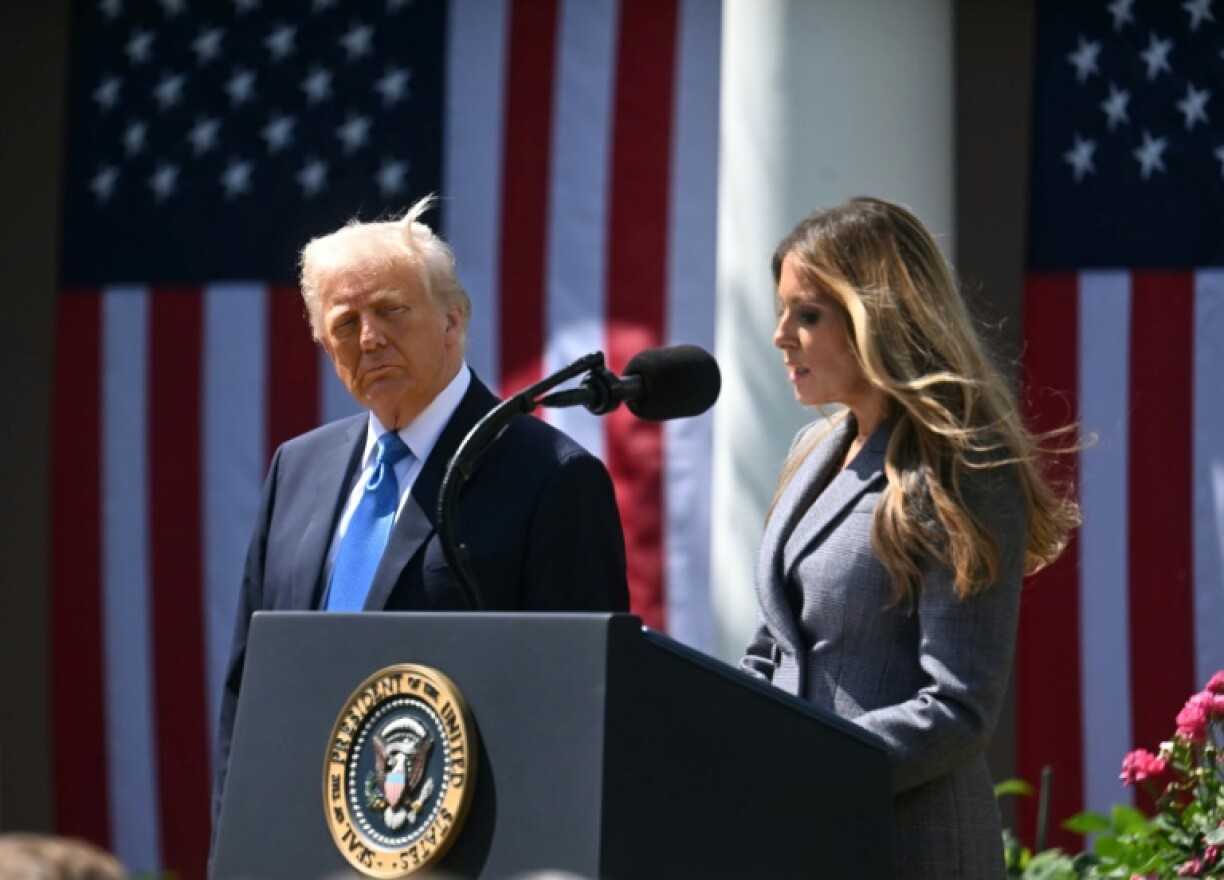 US President Donald Trump looks on as First Lady Melania Trump speaks at a signing ceremony of the