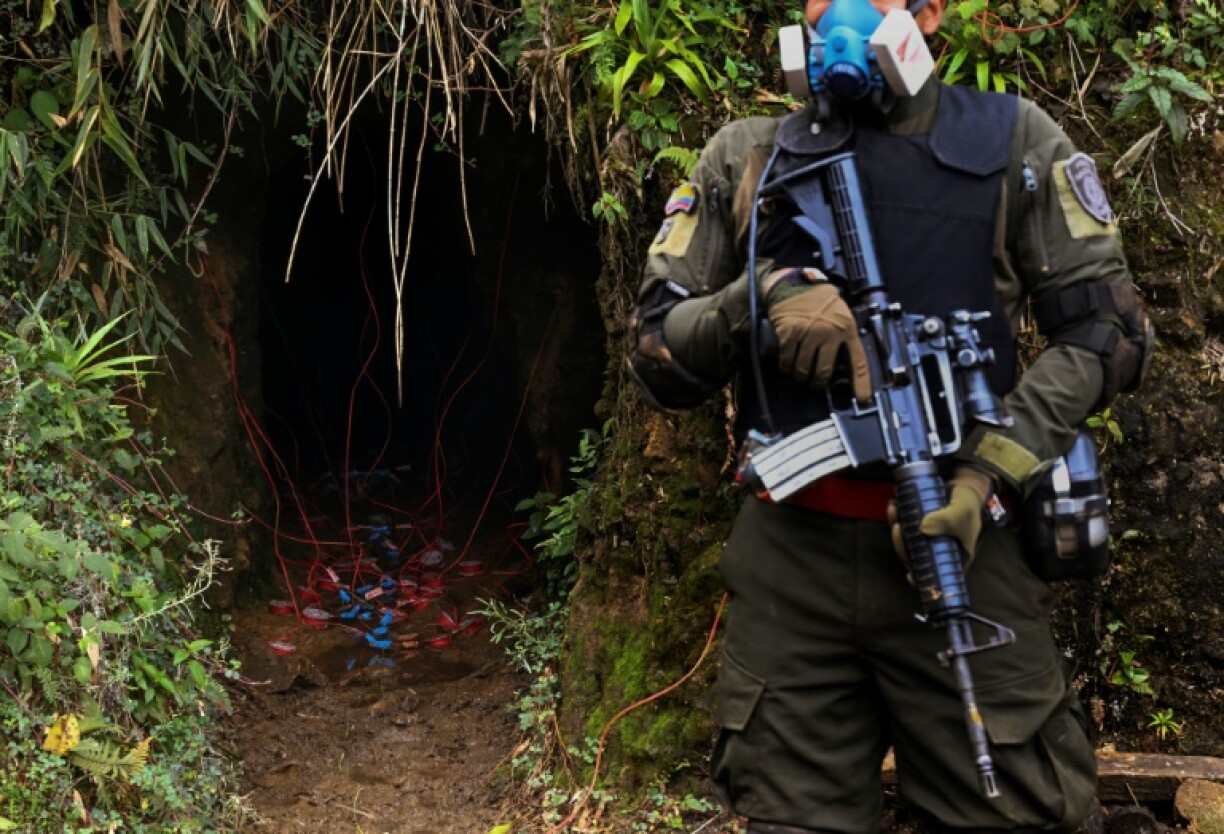 A policeman stands guard as a demolition crew prepares to shut down the mine