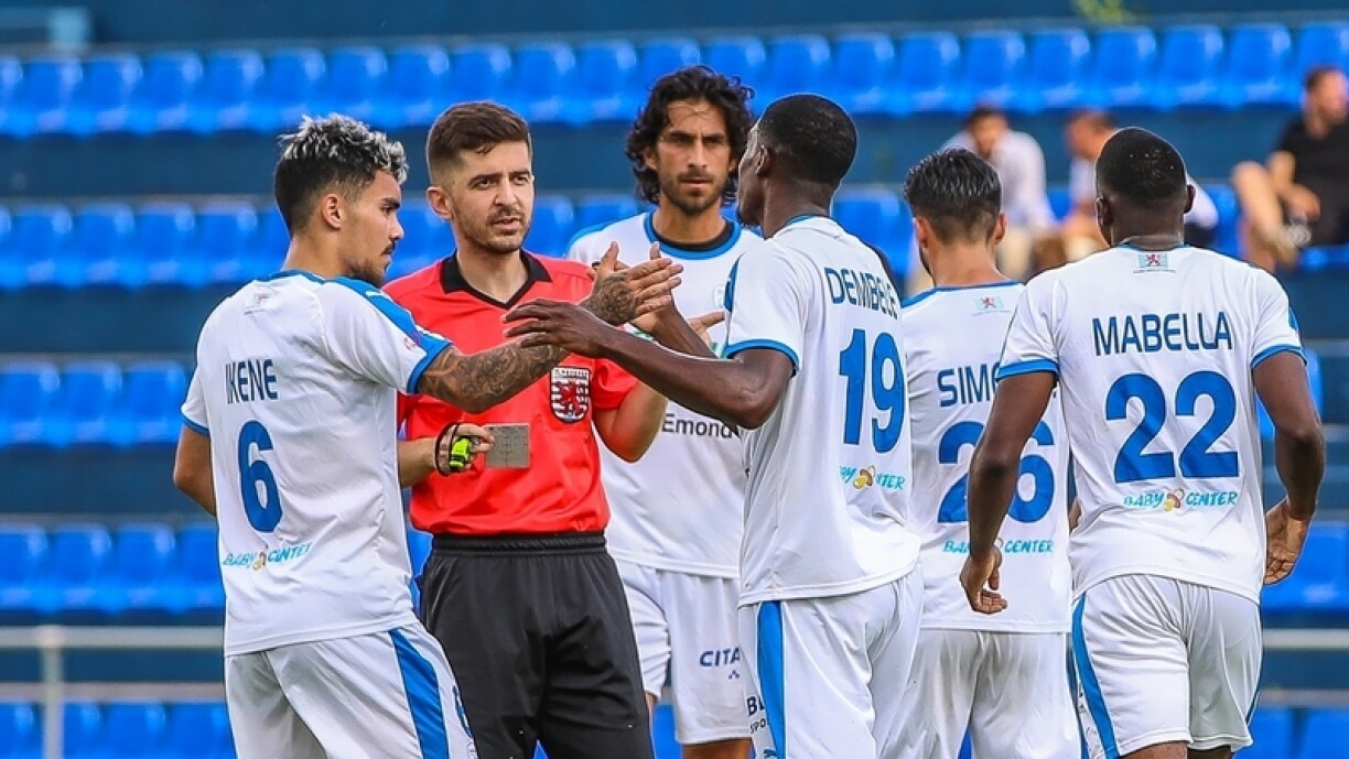 Des joueurs du Racing discutent avec l'arbitre lors d'un match amical contre La Louvière