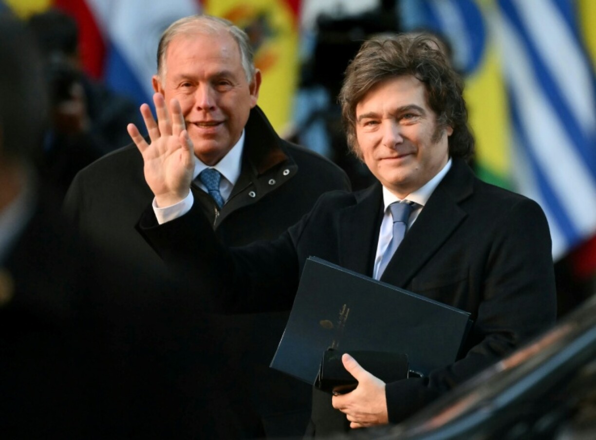 Argentina's self-declared 'anarcho-capitalist' leader Javier Milei waves upon arrival at the Mercosur summit