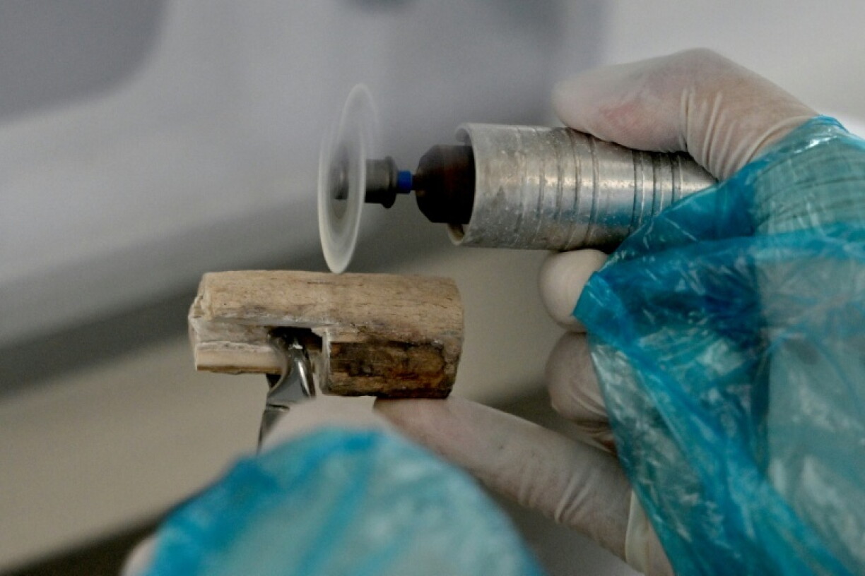 A staff member cuts a bone fragment from the remains of a fallen soldier at the Center for DNA Identification (CDI), which is part of the Vietnam Academy of Science and Technology, in Hanoi