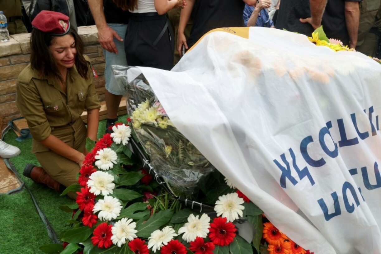 Une soldate israélienne pleure lors des funérailles au cimetière militaire de Netanya, d'un soldat tué dans les combats contre le Hamas dans la bande de Gaza, le 21 juin 2024