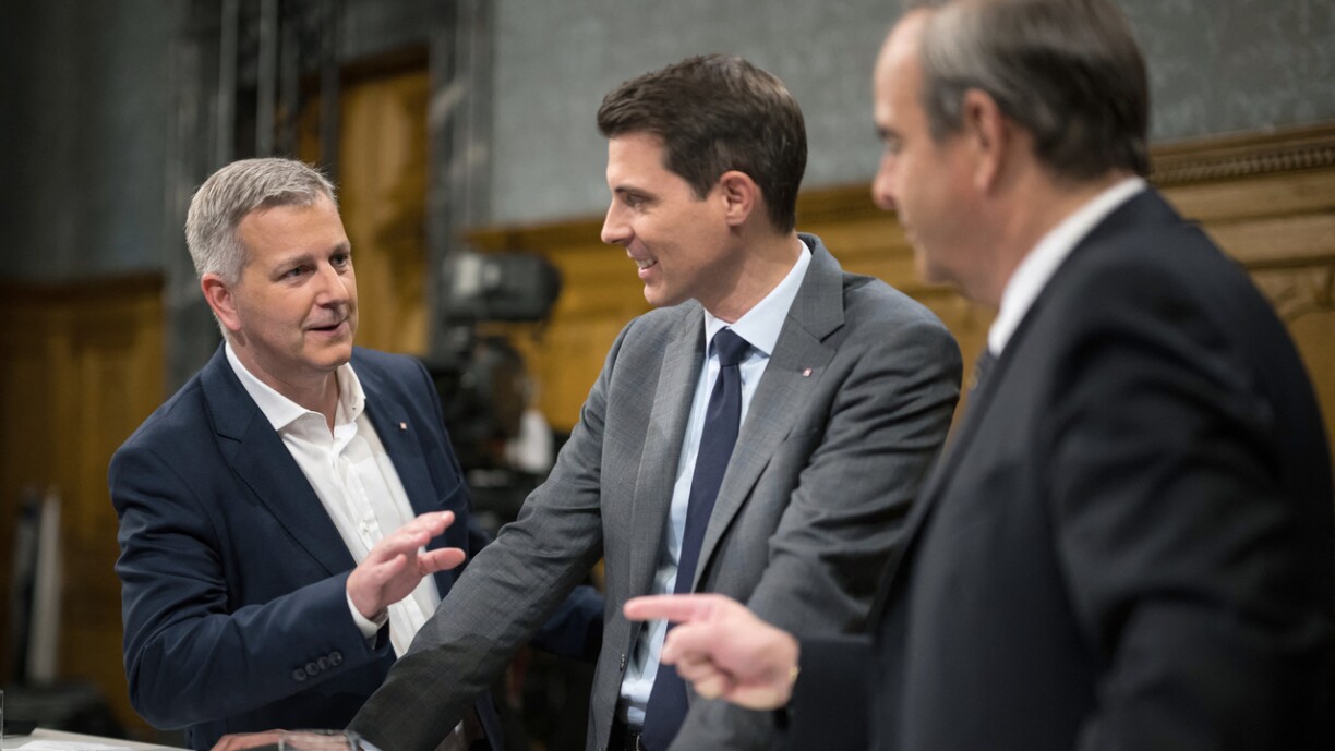 Le leader du parti SVP, Marco Chiesa, discute avec le président du FDP, Thierry Burkart et le président du parti Die Mitte, Gerhard Pfister