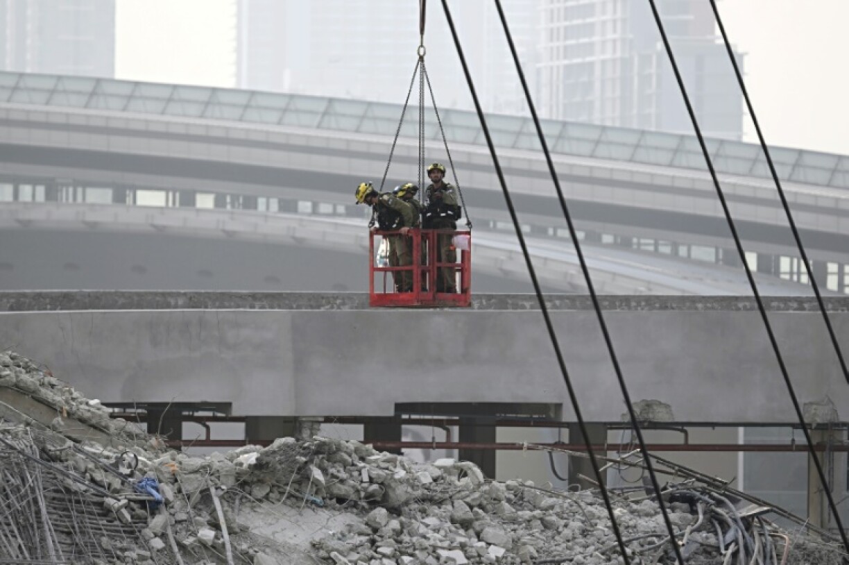 Members of the Israeli Search and Rescue unit are pictured on a crane at the site of an under-construction building collapse in Bangkok