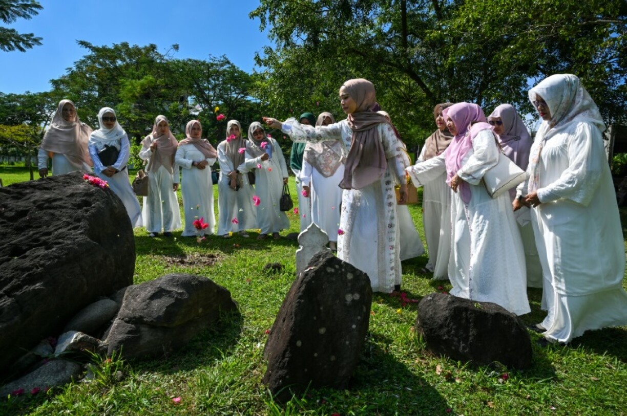 Women prayed for relatives who lost their lives in the 2004 Indian Ocean tsunami at a mass grave in Indonesia