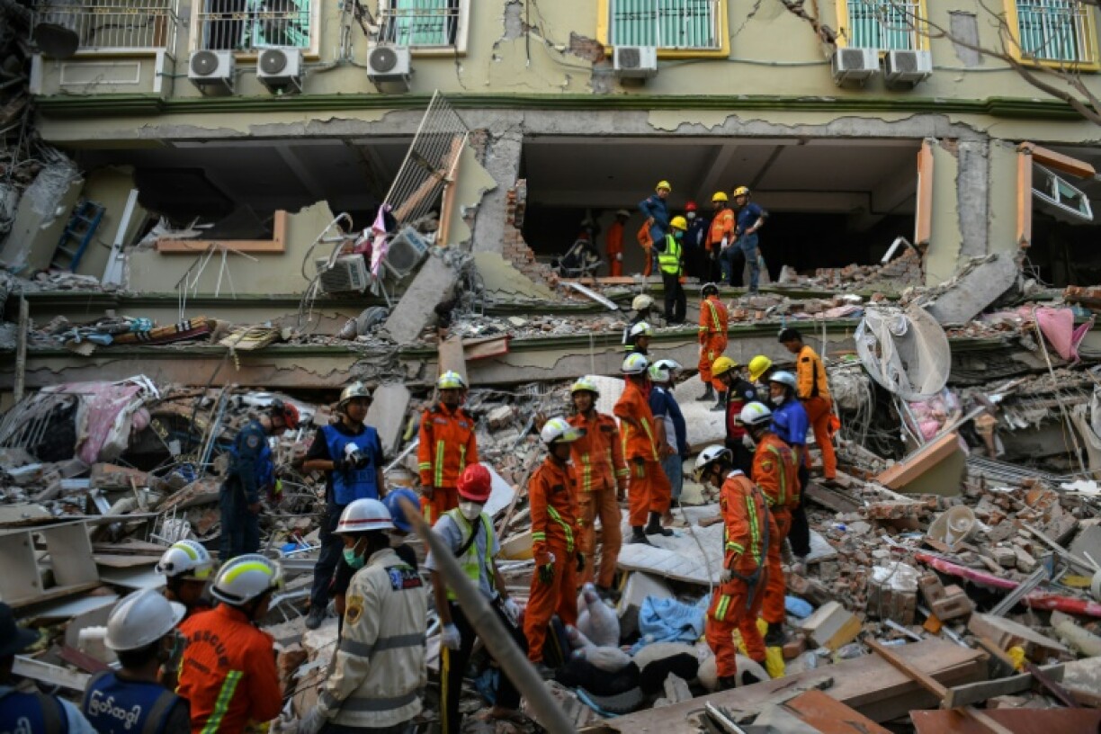 Rescue teams work to reach people believed trapped under the rubble of the collapsed building Sky Villa Condominium in Mandalay