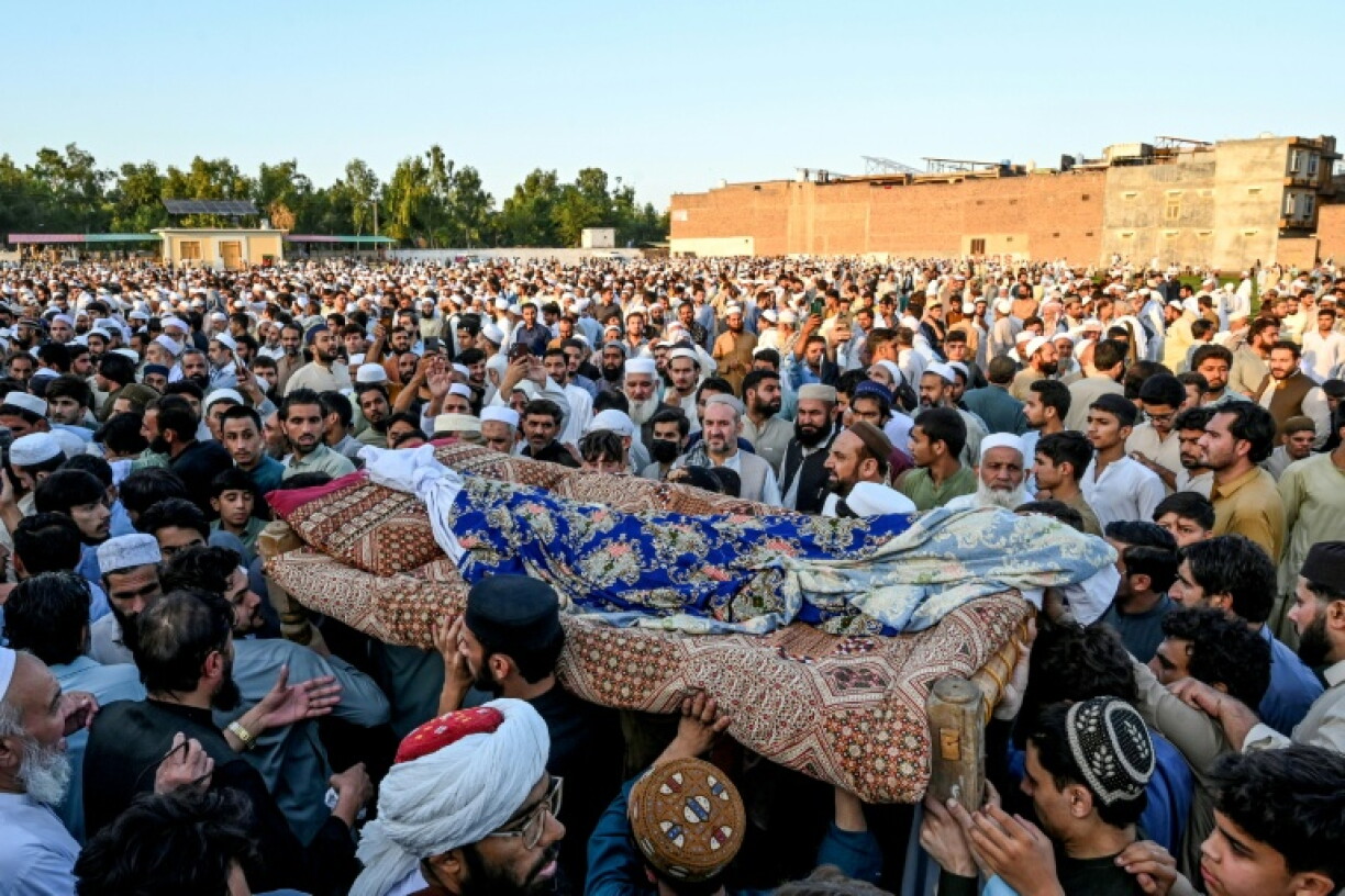 Relatives carry coffins for the funeral prayers of students killed after a roof collapsed at a school in Peshawar