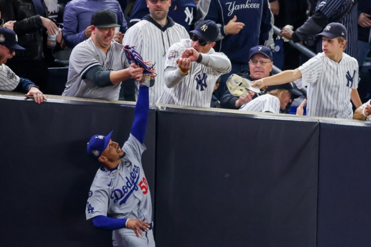 Two spectators who interfered with Mookie Betts of the Los Angeles Dodgers as he tried to catch a fly ball in foul territory at last year's World Series have been banned from all MLB facilities and events