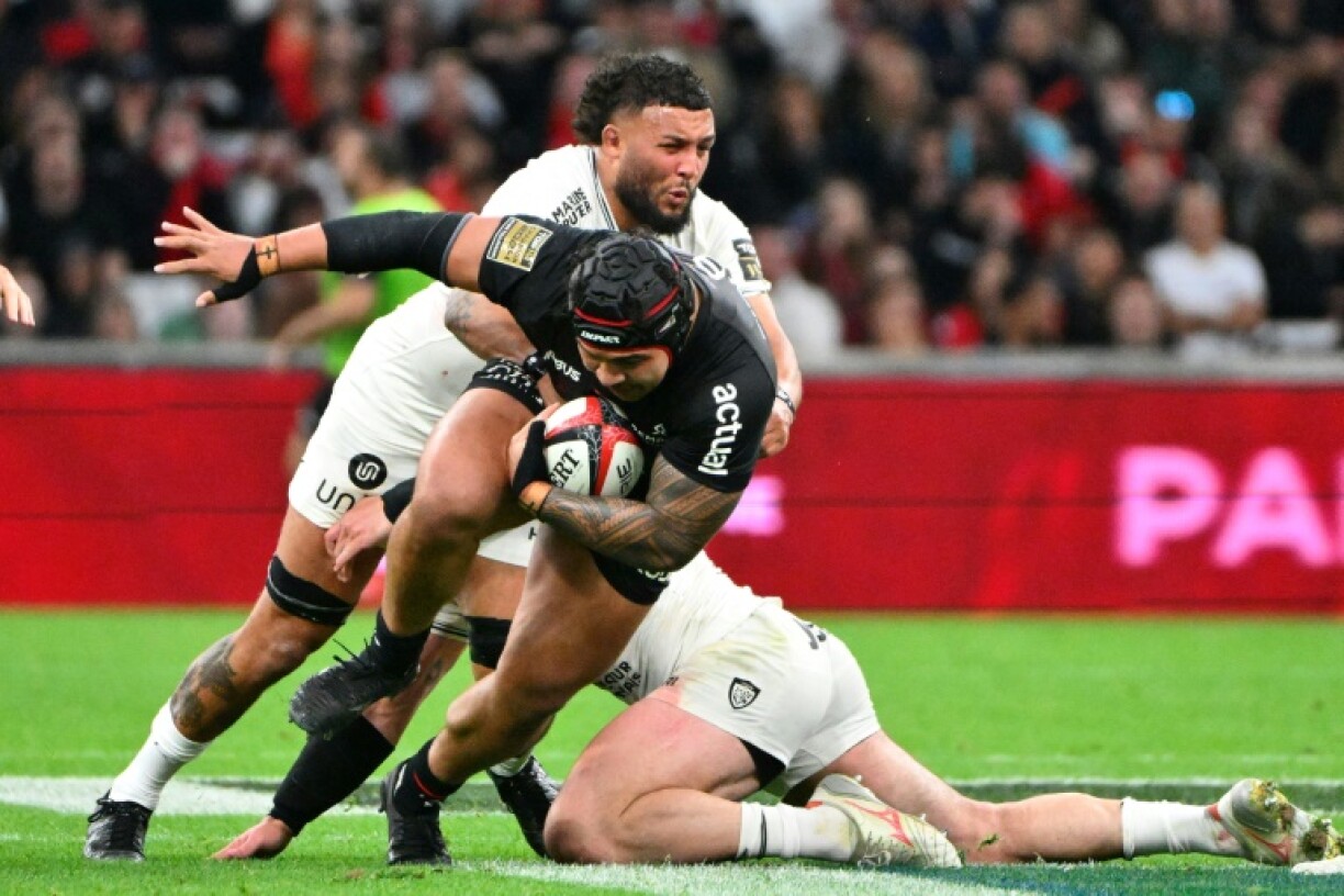 Toulouse prop David Ainu'u (C) is tackled by Toulon flanker Lewis Ludlam in the French Top 14 rugby union match