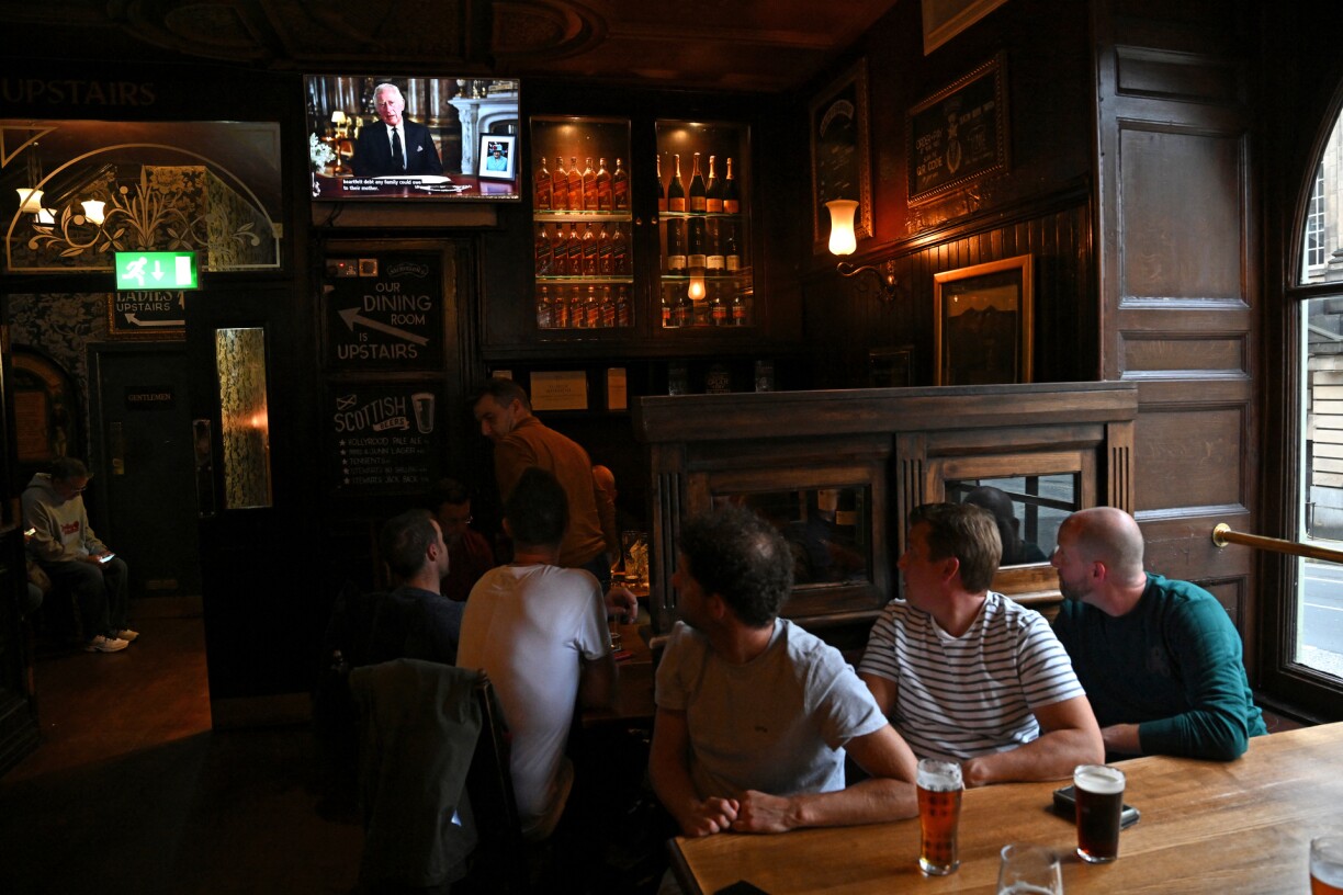 Drinkers in Deacon Brodies Tavern in Edinburgh watch a televised address from Britain's King Charles III, made from the Blue Drawing Room at Buckingham Palace in London on September 9, 2022
