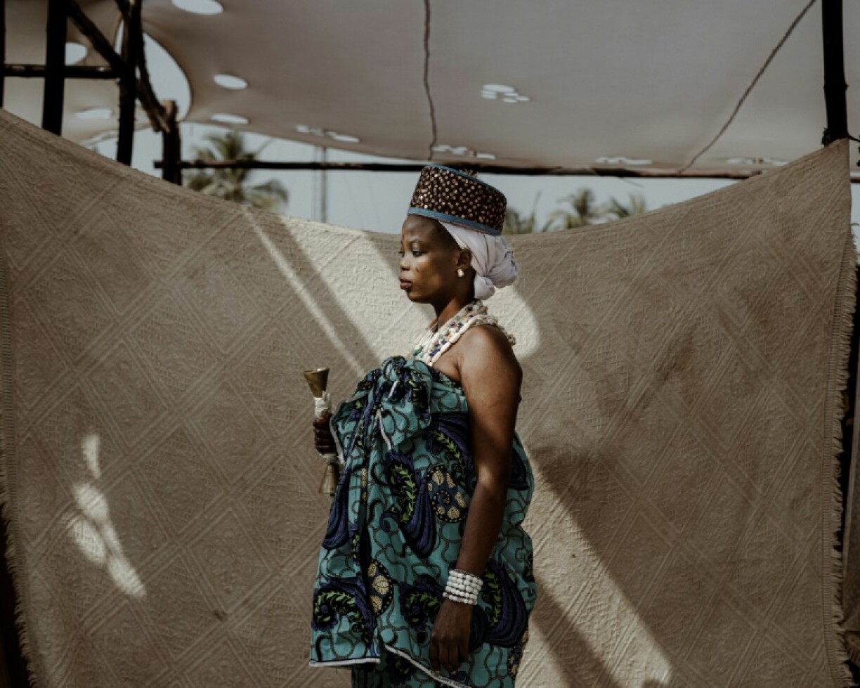 A woman outside the temple of Mami Wata, an aquatic deity for voodoo practitioners