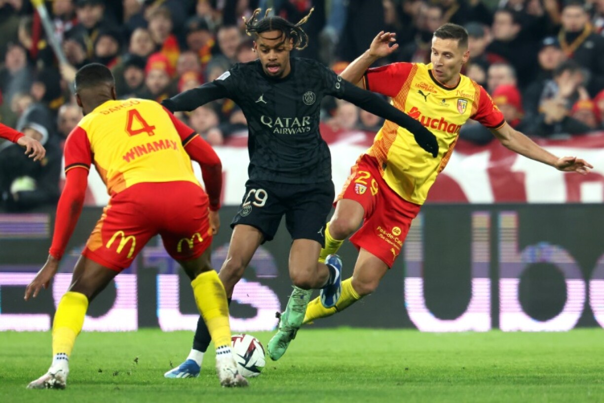 L'attaquant du PSG Bradley Barcola chaloupe entre deux défenseurs de Lens en Ligue 1 le 14 janvier 2024 au stade Bollaert à Lens
