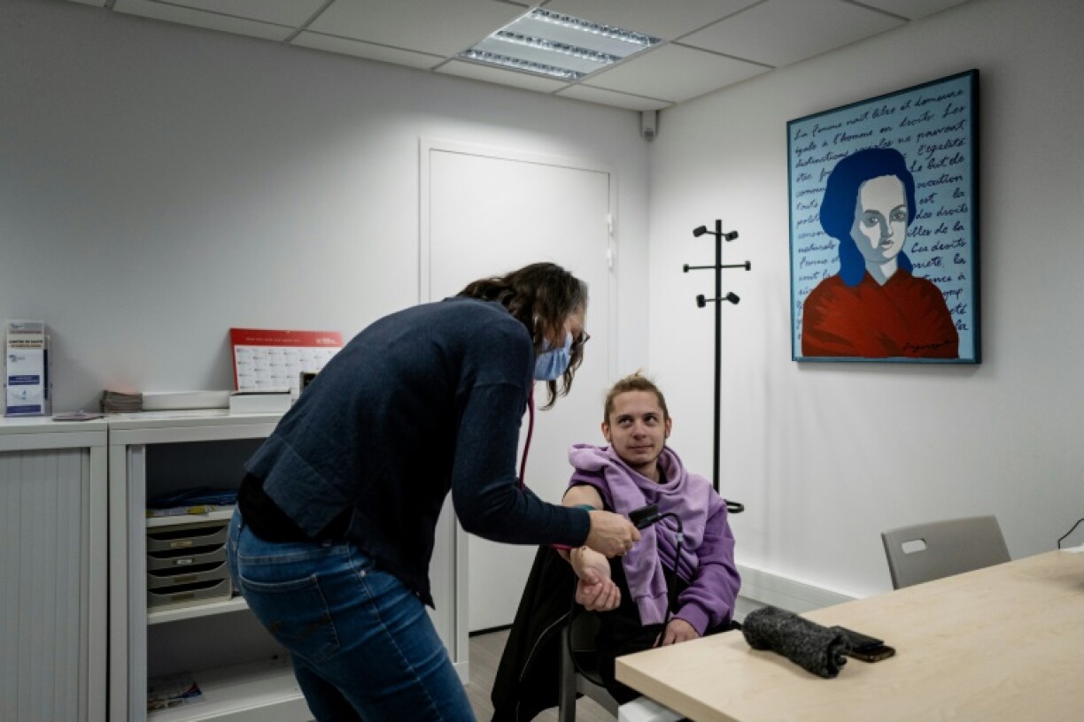 A doctor checks Isaac's blood pressure at the 25 Gisele Halimi centre