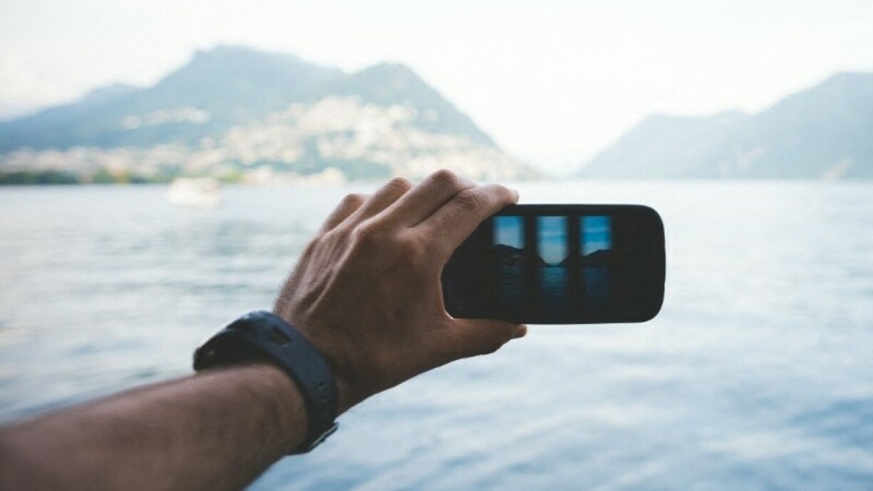 Un homme prenant des photos au lac de Lugano en Suisse.