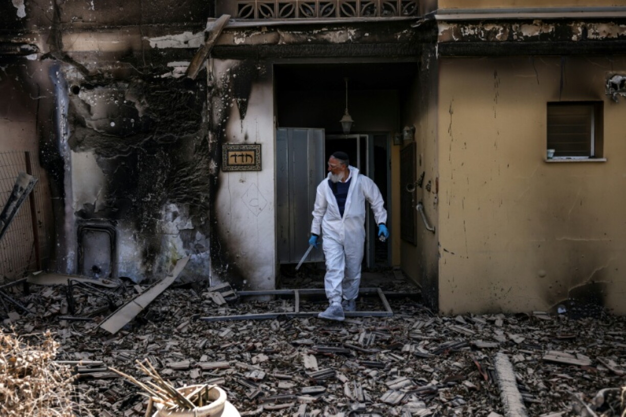 A volunteer of the Zaka Israeli ultra-Orthodox Jewish emergency response team searches through the debris in Kibbutz Beeri near the border with Gaza on October 20, 2023, in the aftermath of an attack by Palestinian militants on October 7