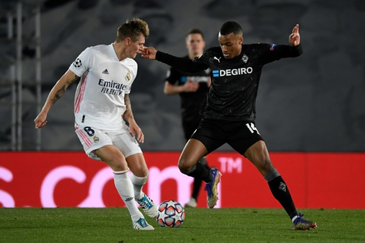 Le milieu français de Mönchengladbach, Alassane Pléa (d), au duel avec le milieu allemand du Real Madrid, Toni Kroos, lors du match de groupes de la Ligue des champions à Valdebebas, le 9 décembre 2020