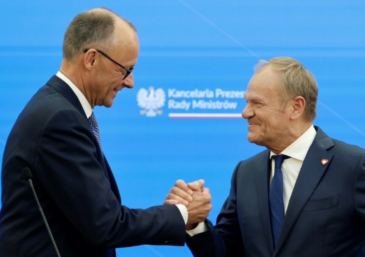 Gereman Chancellor Friedrich Merz and Polish Prime Minister Donald Tusk shake hands at a Warsaw press conference