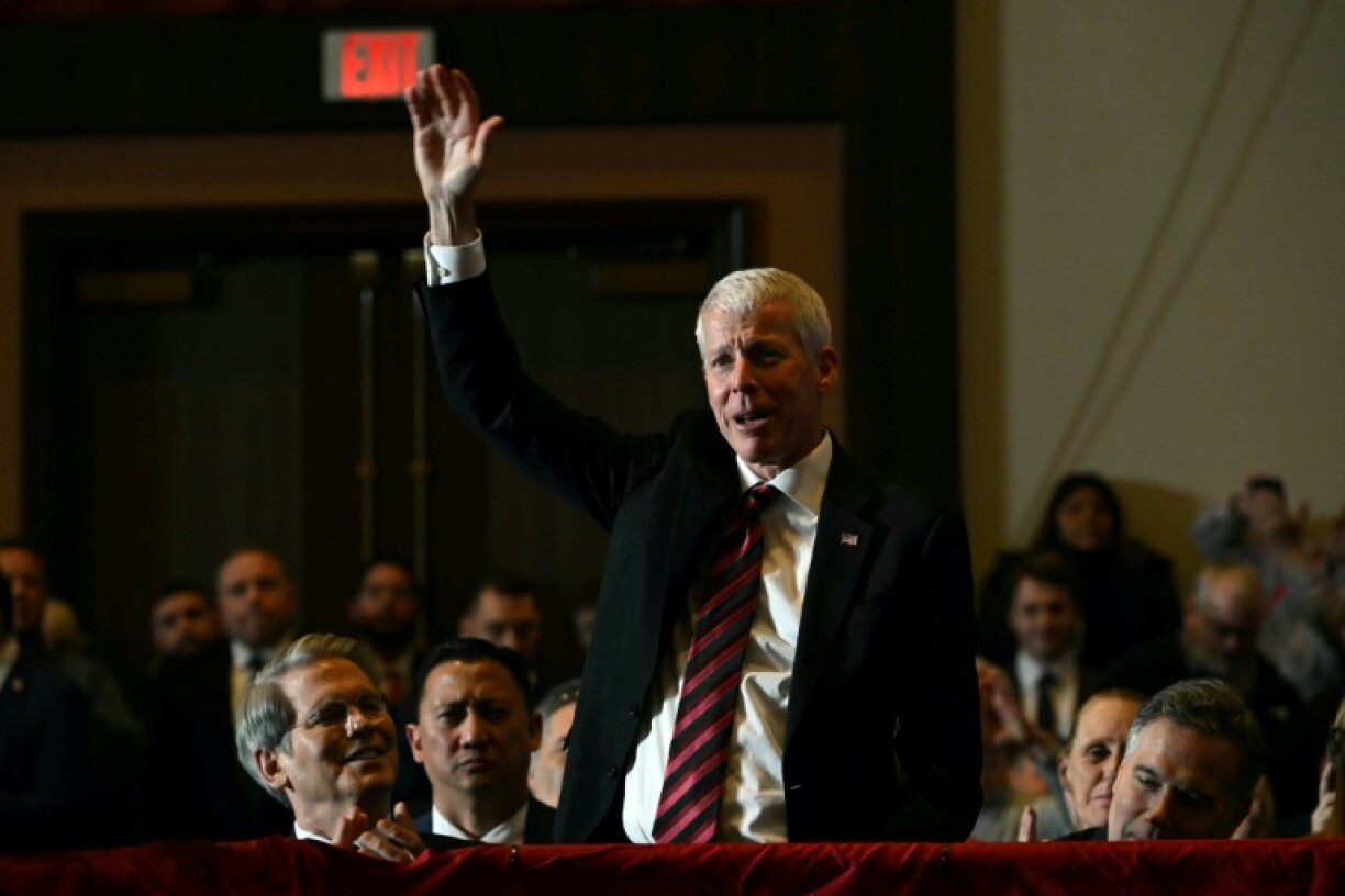 Le ministre américain de l'Energie, Chris Wright, lève la main alors que le président Donald Trump (non visible sur la photo) prononce un discours, en Pennsylvanie, le 9 décembre 2025