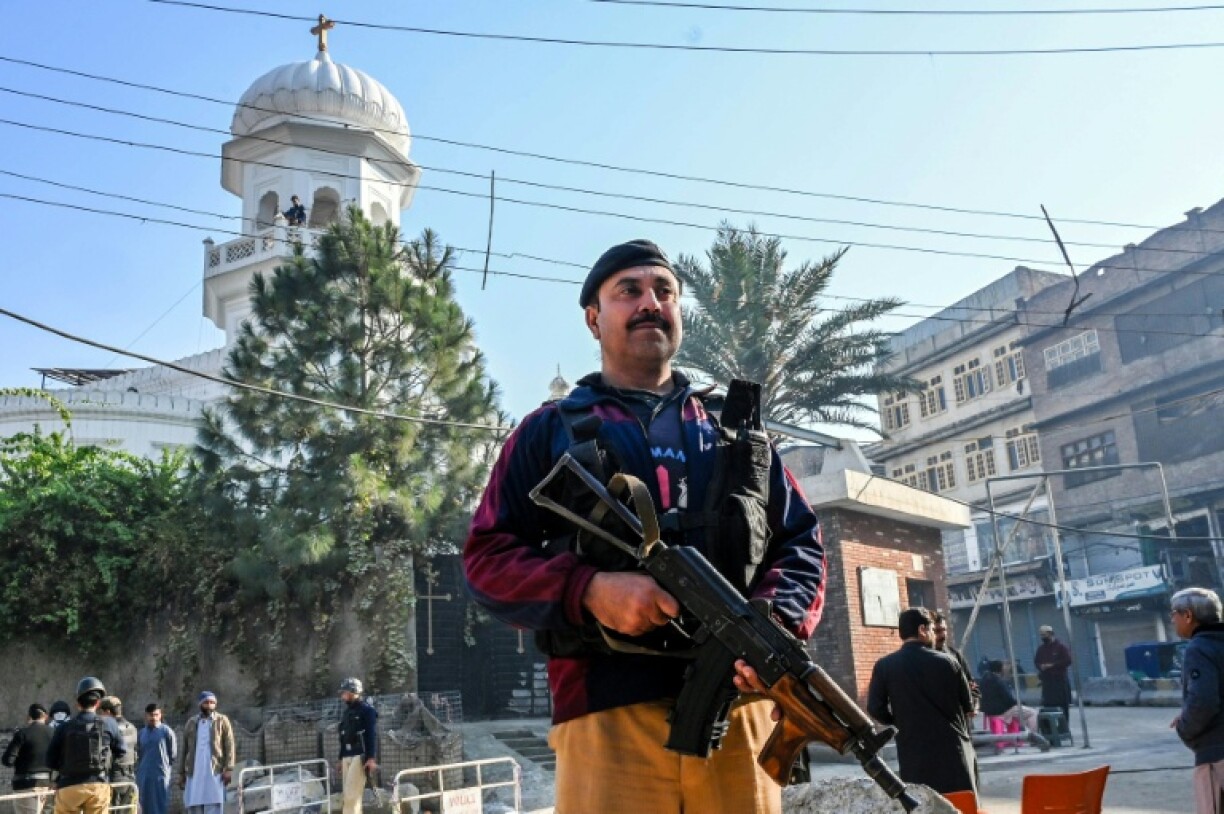 Un policier monte la garde devant l'église All Saints de Peshawar à l'occasion de Noël, le 25 décembre 2025 au Pakistan