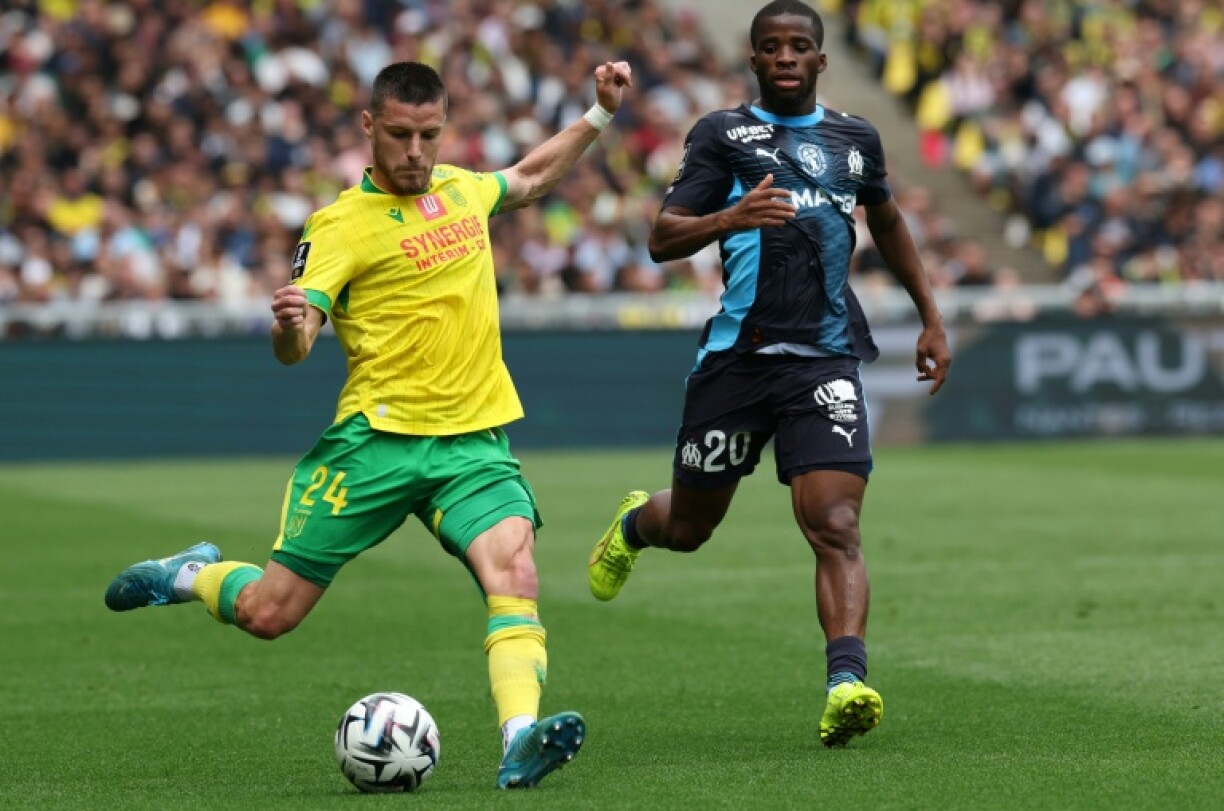 Le défenseur nantais Frederic Guilbert (g) dégage le ballon sous le regard du marseillais Hamed Junior Traore lors du match de Ligue 1 entre Nantes et Marseille, le 2 mai 2026 à Nantes