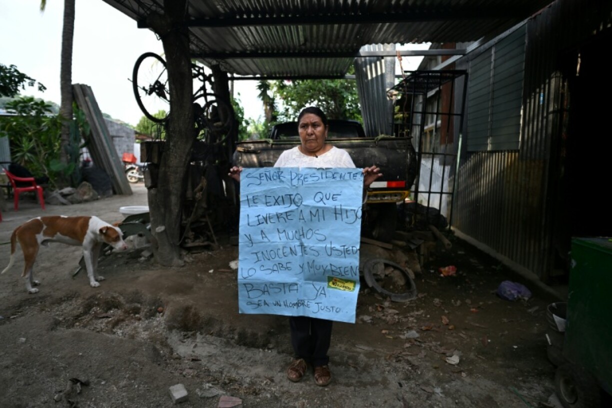Juana Fuentes, 54, holds a sign addressed to President Nayib Bukele calling for the release of her son Nelson Antonio Fuentes, 23, imprisoned since April 2022