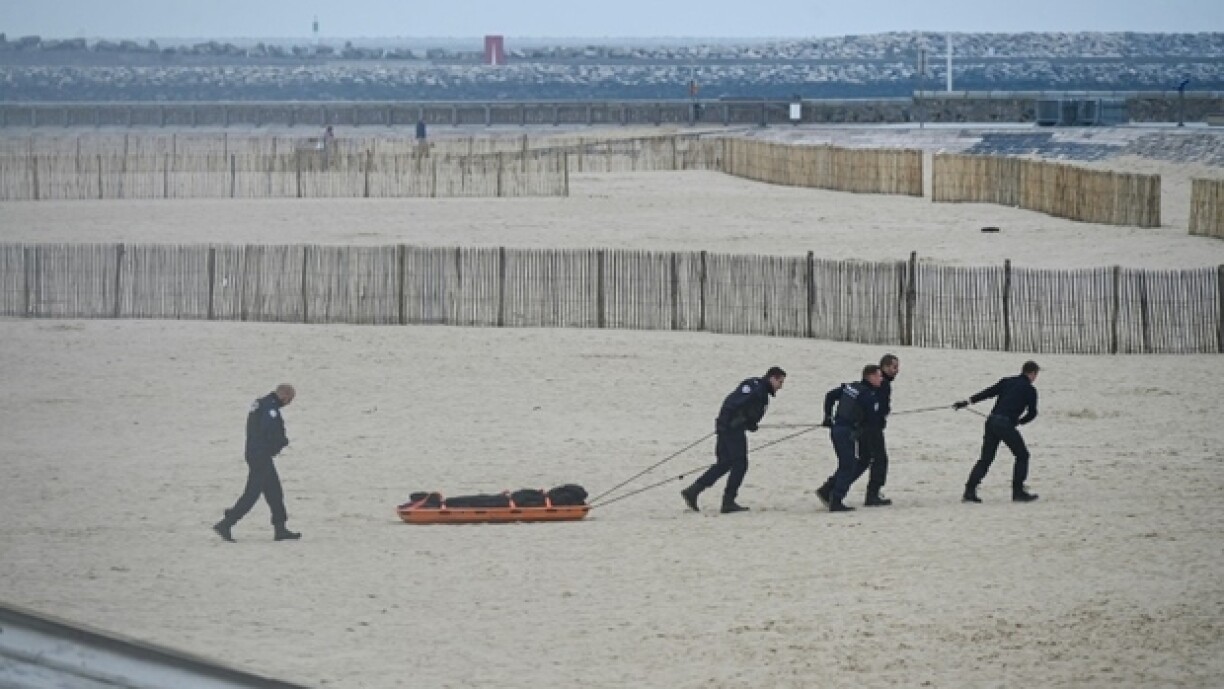 Des agents de police évacuent un corps découvert sur la plage de Calais, d'où de nombreux migrants tentent la périlleuse traversée de la Manche, le 6 novembre 2024