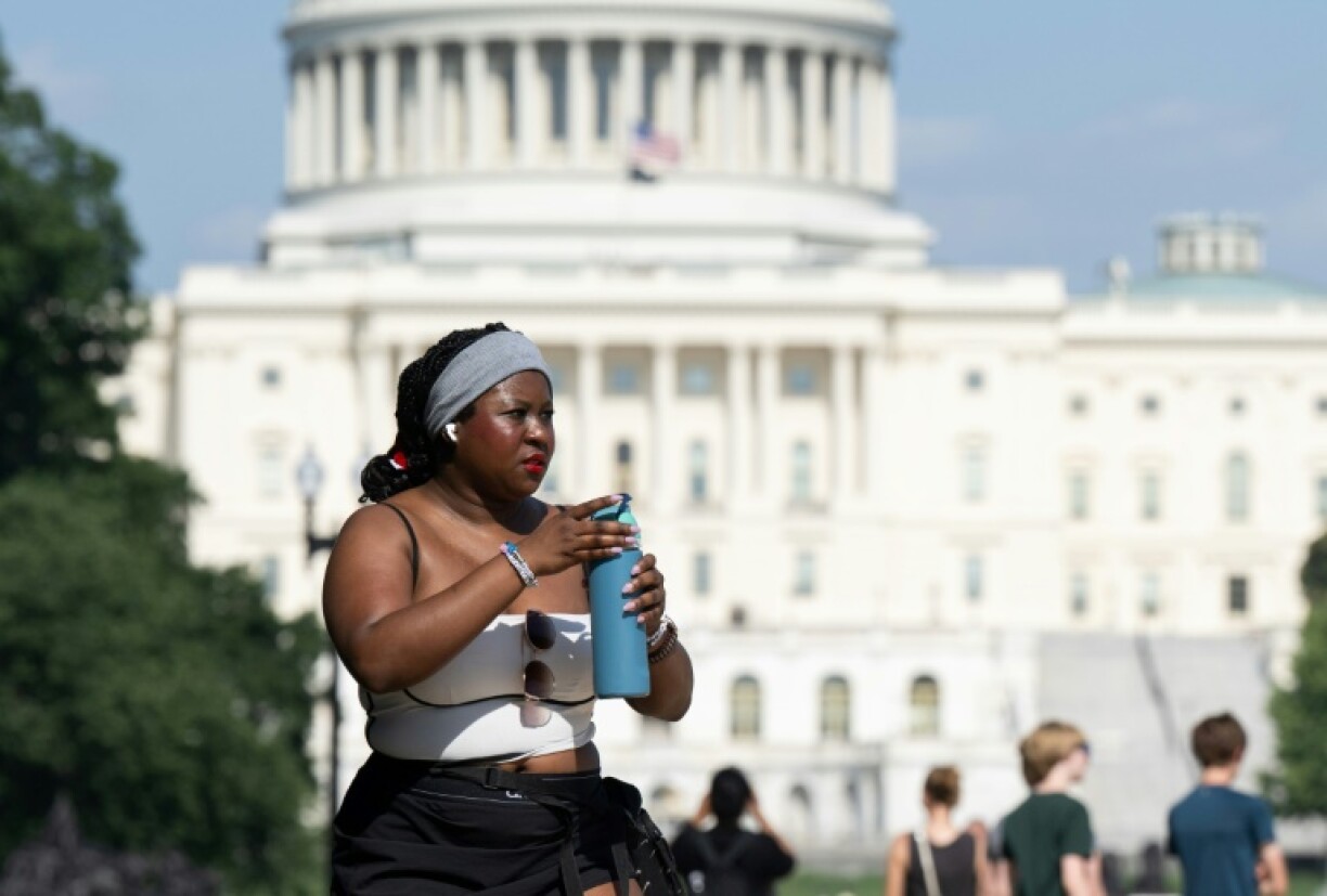 A person drinks from a canister near the US Capitol on the National Mall in Washington, DC in June 2025, as a significant heat wave hits the region