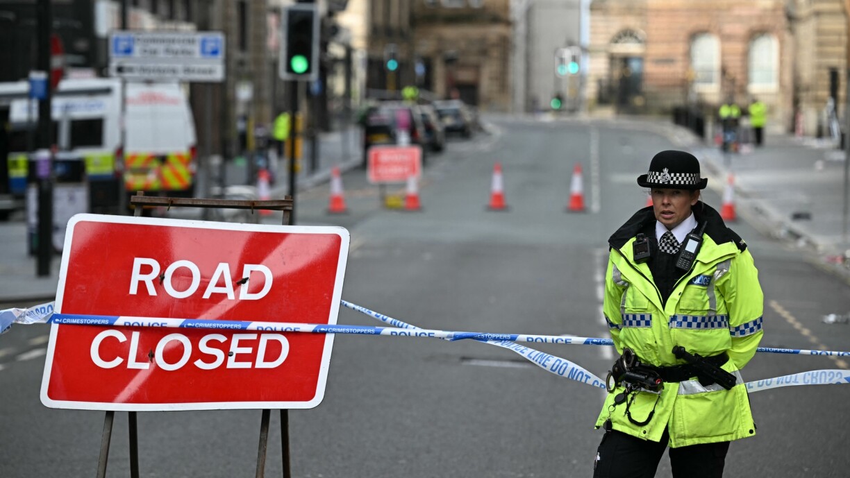 Police officers stand at a cordon in Liverpool, north-west England on 27 May after a car ploughed in to crowds gathered on Water Street to watch an open-top bus victory parade for Liverpool's Premier League trophy parade on 26 May 2025.